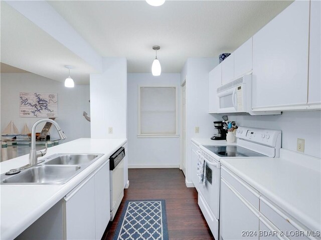 kitchen with pendant lighting, white appliances, dark wood-type flooring, sink, and white cabinetry