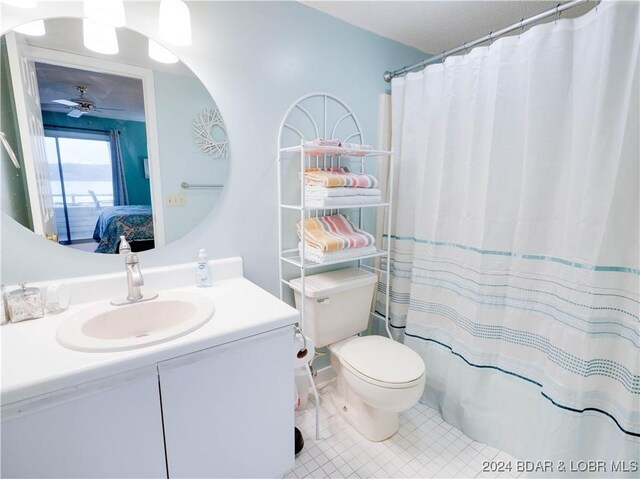 bathroom with a shower with curtain, ceiling fan, vanity, and toilet