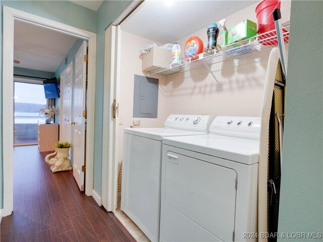 laundry area with electric panel, washer and clothes dryer, and dark hardwood / wood-style flooring