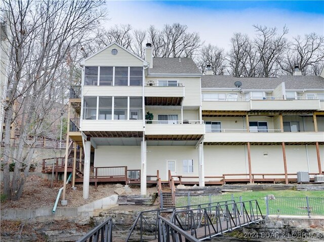 back of house featuring a sunroom and cooling unit