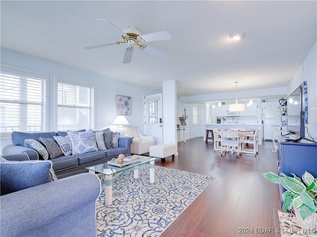 living room with ceiling fan and dark wood-type flooring