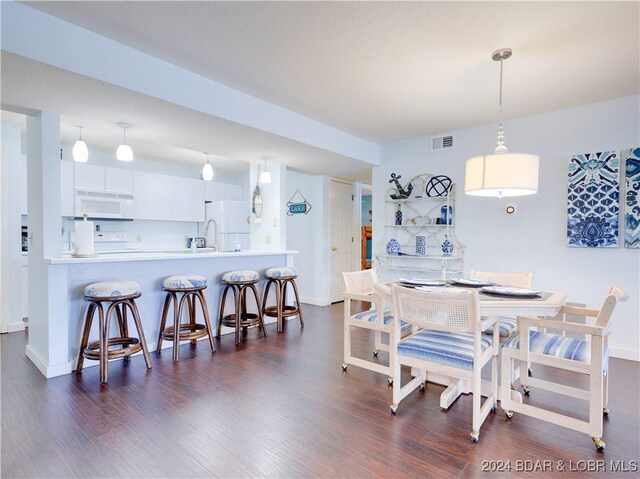 dining space featuring dark hardwood / wood-style floors and sink