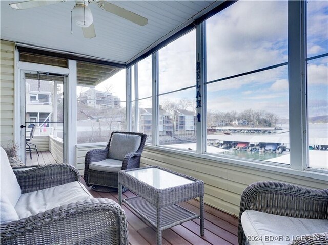 sunroom / solarium with a water view and ceiling fan