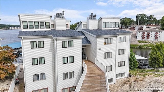 view of building exterior with a water view and central AC unit