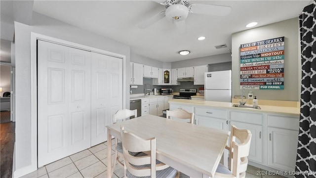 kitchen with sink, white cabinets, light tile patterned floors, ceiling fan, and stainless steel appliances