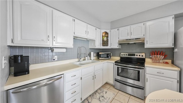 kitchen with appliances with stainless steel finishes, sink, and white cabinets