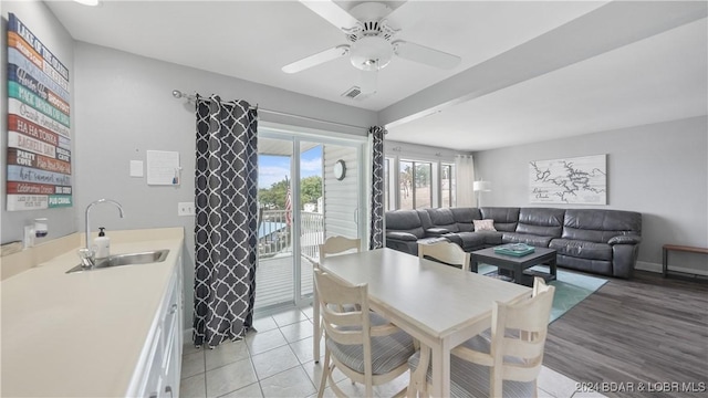 dining area with ceiling fan, sink, and light tile patterned floors