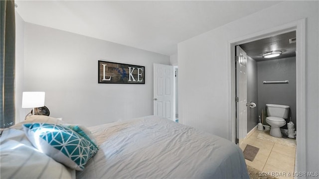 bedroom featuring ensuite bathroom and light tile patterned floors