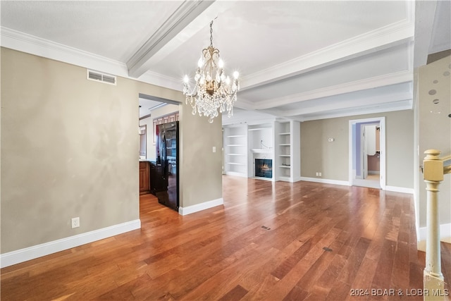 unfurnished living room featuring beamed ceiling, built in shelves, an inviting chandelier, and wood-type flooring