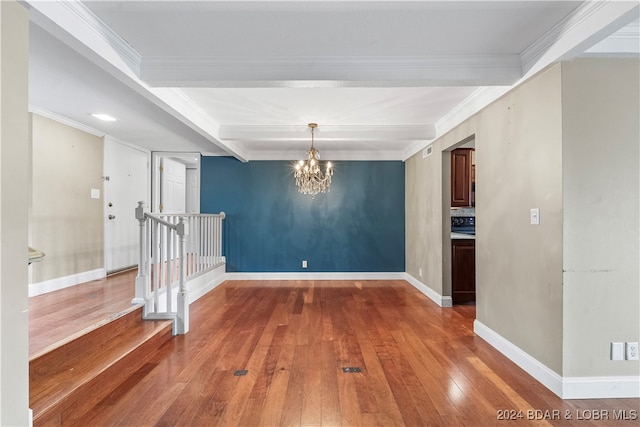 interior space featuring wood-type flooring, an inviting chandelier, crown molding, and beam ceiling