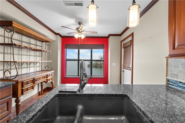 kitchen featuring dark stone countertops, ornamental molding, sink, and tasteful backsplash