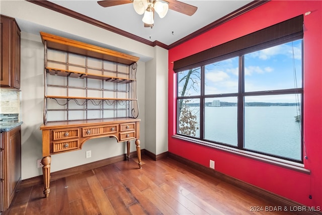 home office featuring ceiling fan, a water view, ornamental molding, and wood-type flooring