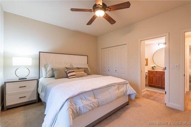 carpeted bedroom featuring connected bathroom, ceiling fan, and a closet