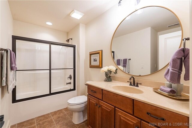 full bathroom with tile patterned floors, toilet, vanity, and combined bath / shower with glass door