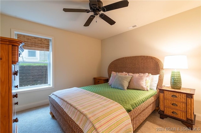 bedroom featuring a ceiling fan, light carpet, visible vents, and baseboards