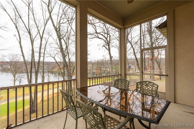 sunroom / solarium featuring a water view and a healthy amount of sunlight