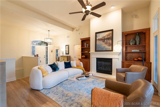 living room featuring light hardwood / wood-style floors and ceiling fan with notable chandelier