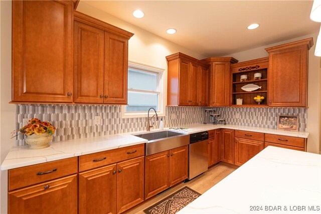 kitchen featuring dishwasher, light hardwood / wood-style floors, decorative backsplash, and sink