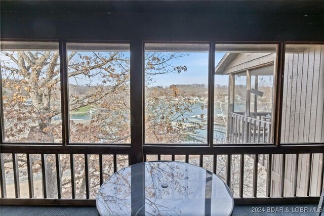 unfurnished sunroom featuring a water view