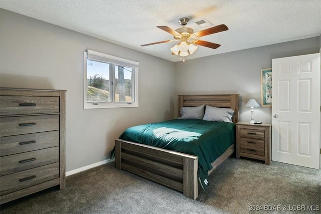 bedroom with a textured ceiling, dark carpet, and ceiling fan