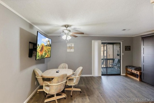 dining area with a textured ceiling, dark wood-type flooring, ceiling fan, and ornamental molding