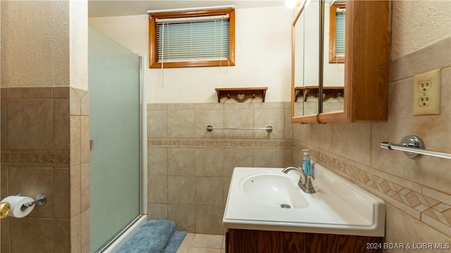 full bath featuring tile patterned flooring, a shower stall, tile walls, and vanity