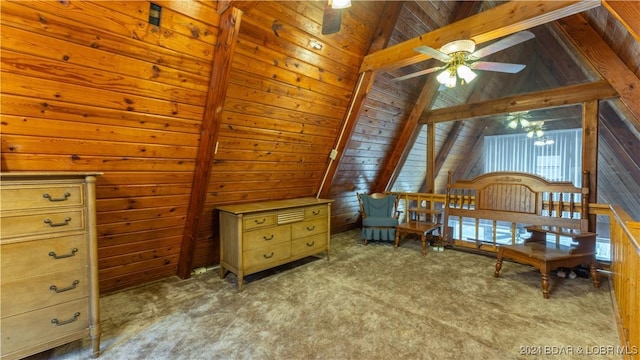 living area featuring carpet floors, wood walls, lofted ceiling with beams, and ceiling fan