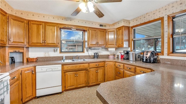 kitchen featuring white appliances, brown cabinetry, a sink, and wallpapered walls