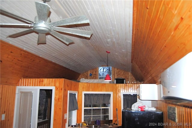 interior space with ceiling fan, sink, wood walls, fridge, and wood ceiling