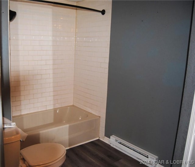 bathroom with hardwood / wood-style floors, toilet, tiled shower / bath, and a baseboard heating unit