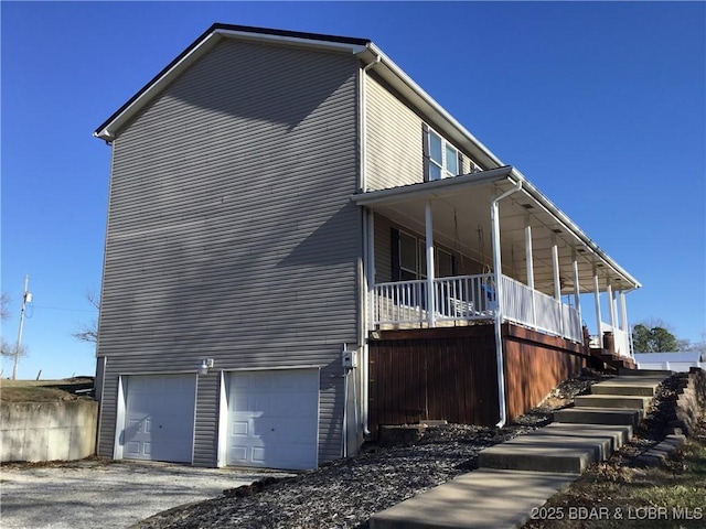 view of property exterior with covered porch and a garage