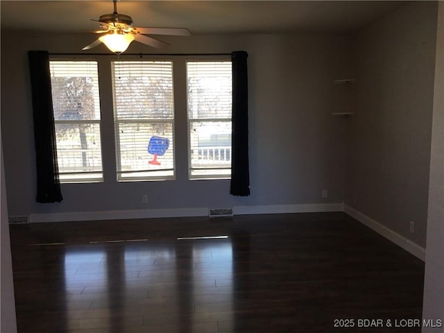 empty room featuring ceiling fan and dark hardwood / wood-style floors