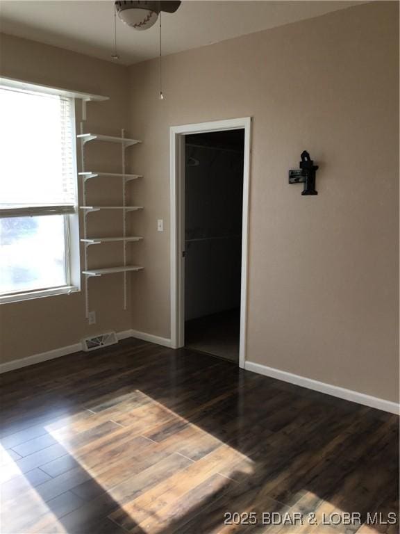 spare room featuring ceiling fan and dark wood-type flooring