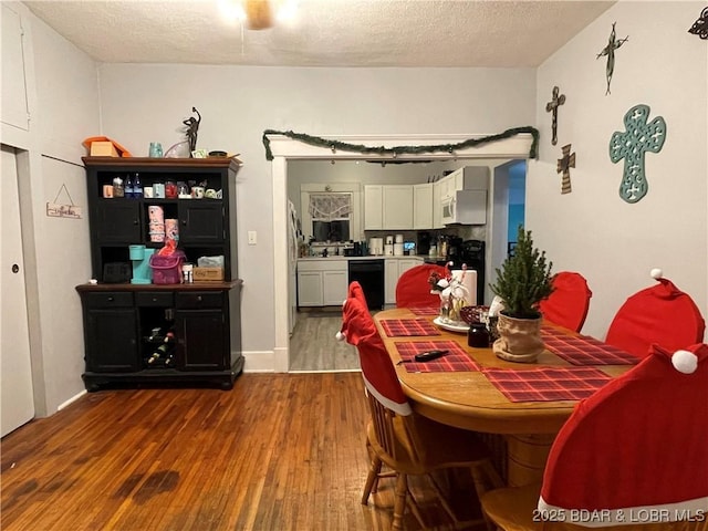 dining area featuring hardwood / wood-style flooring and a textured ceiling