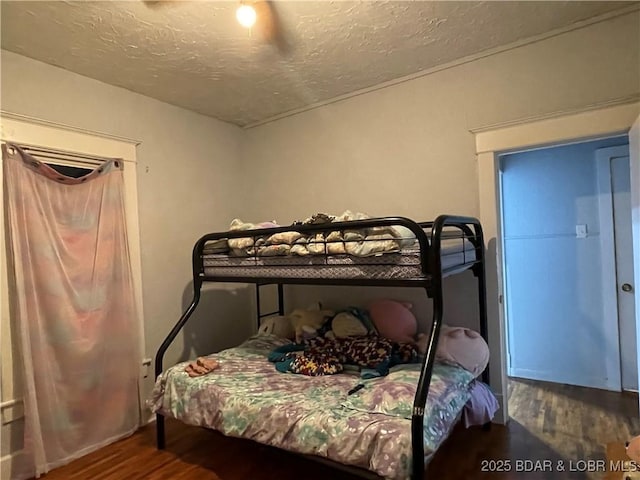 bedroom with hardwood / wood-style flooring, a textured ceiling, and ceiling fan