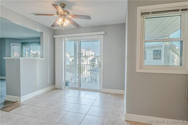 interior space with light tile patterned floors, a textured ceiling, a wealth of natural light, and ceiling fan