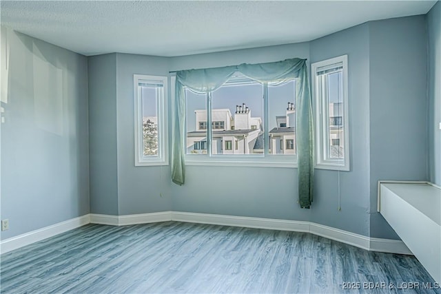 unfurnished room featuring wood-type flooring and a textured ceiling