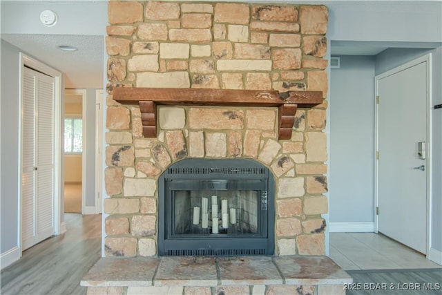 details with a fireplace, hardwood / wood-style floors, and a textured ceiling