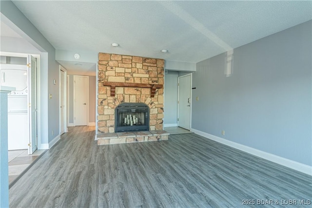 unfurnished living room with a fireplace, a textured ceiling, and hardwood / wood-style flooring