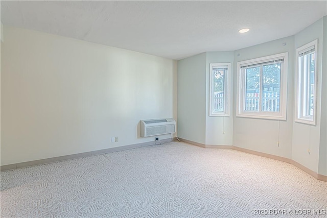 spare room featuring carpet flooring and a wall unit AC