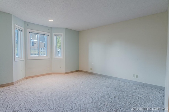 carpeted spare room featuring a textured ceiling