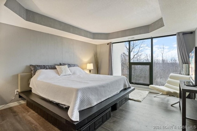 bedroom with wood-type flooring and expansive windows