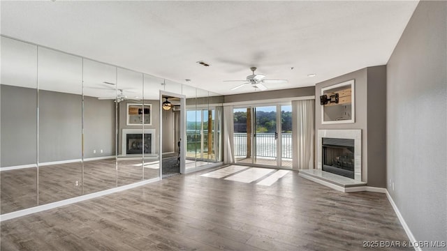 unfurnished living room with hardwood / wood-style floors and ceiling fan