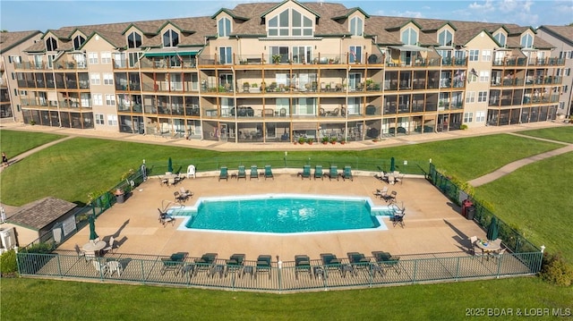 view of pool with a patio area and a yard