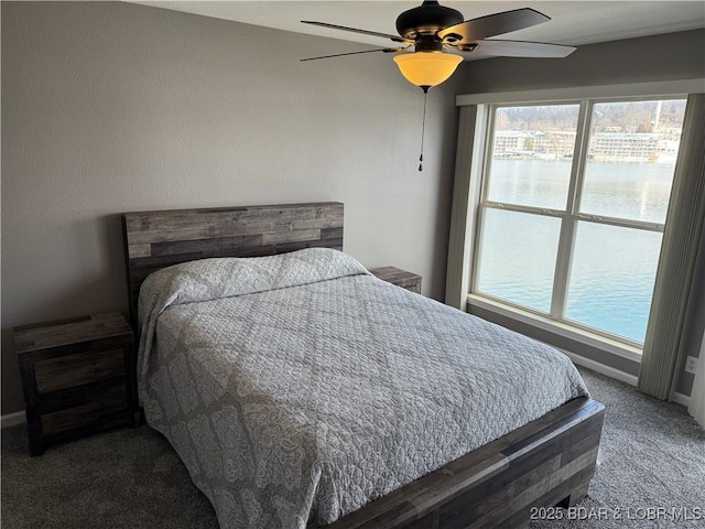 bedroom with a water view, ceiling fan, and carpet