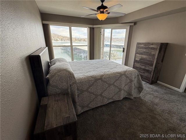 carpeted bedroom featuring access to exterior, ceiling fan, and a water view