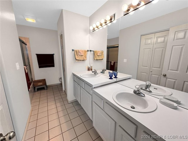 bathroom featuring tile patterned floors, vanity, a shower with shower door, and toilet