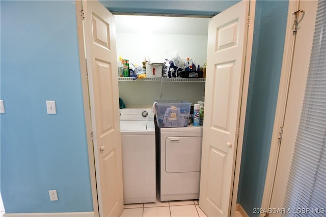 laundry area with washer and clothes dryer and light tile patterned floors