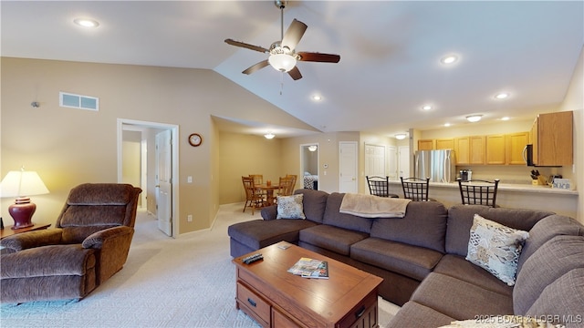 living room featuring light colored carpet, vaulted ceiling, and ceiling fan