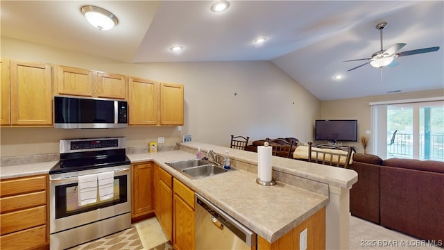 kitchen with sink, vaulted ceiling, ceiling fan, kitchen peninsula, and stainless steel appliances